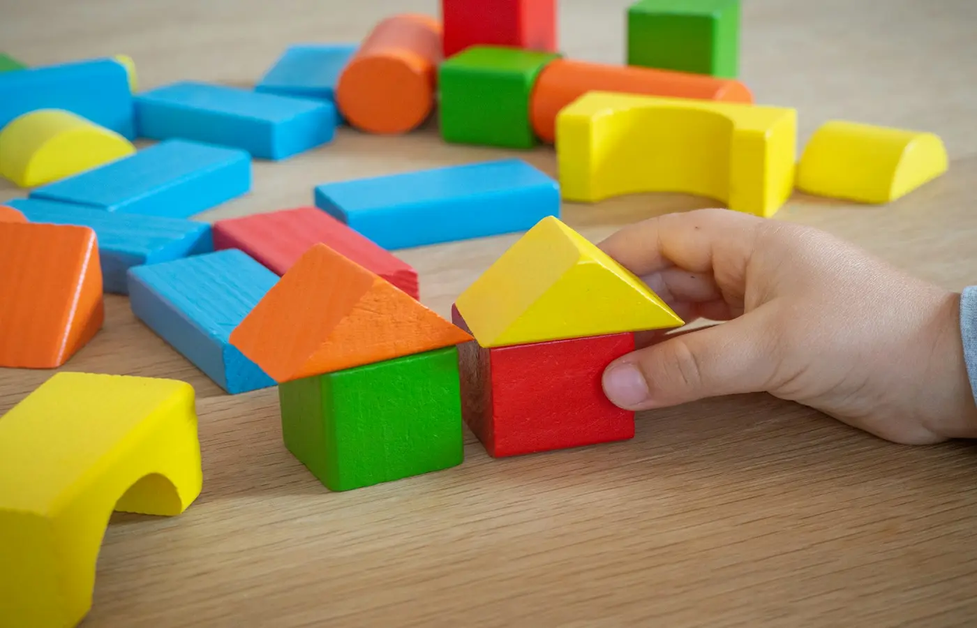 A child building with blocks on the floor.